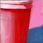closeup of an original oil painting of a pink and red take away coffee cup on a textured bright pink background with strong greyish blue shadows
