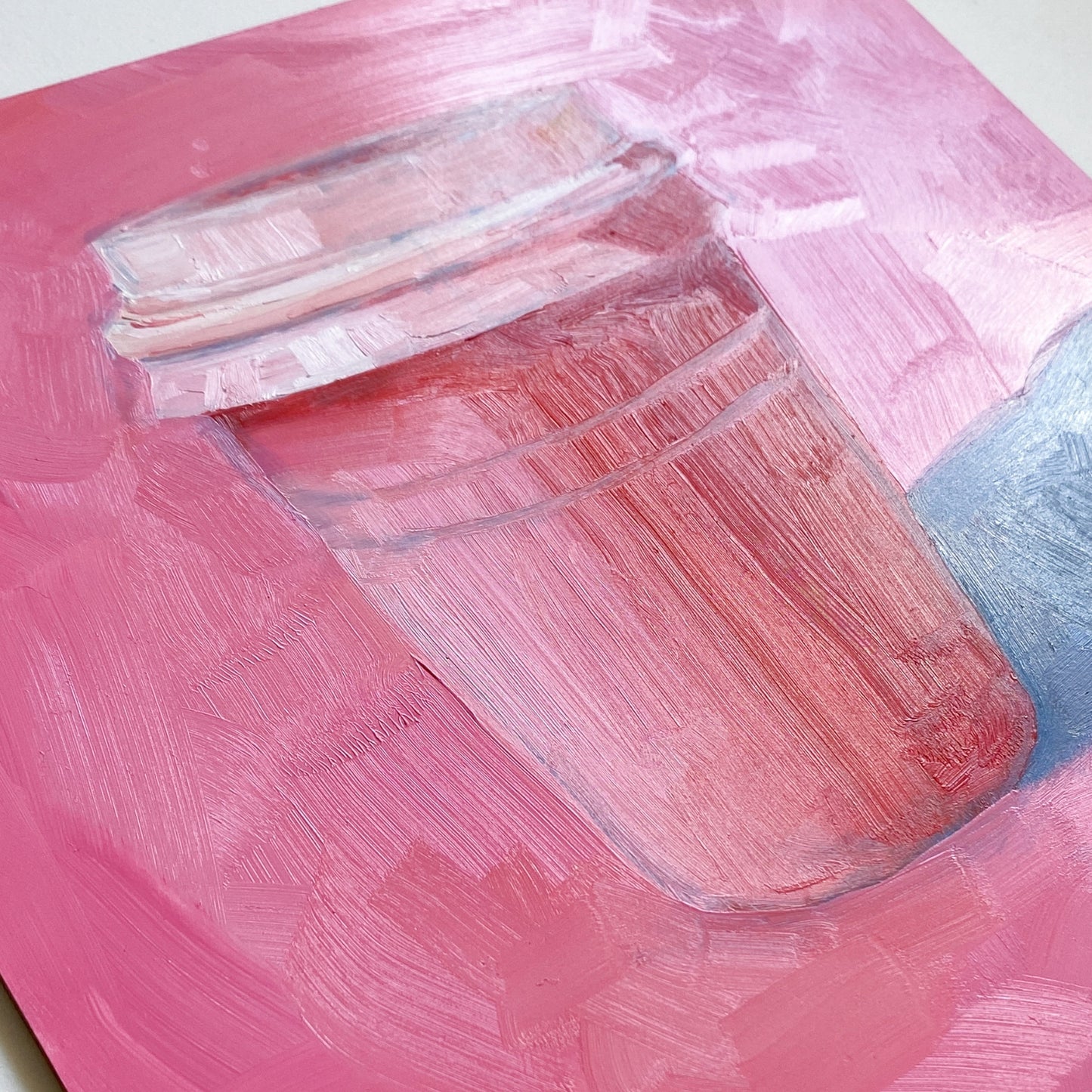 closeup of an original oil painting of a pink and red take away coffee cup on a textured bright pink background with strong greyish blue shadows.