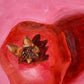 closeup of an original oil painting of a bright and vibrant red pomegranate with a strong reddish shadow on a textured pink background